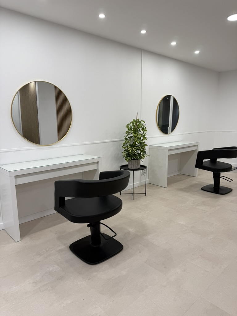 Les deux postes du salon Axel Rombaut, miroirs dorés et fauteuils noirs